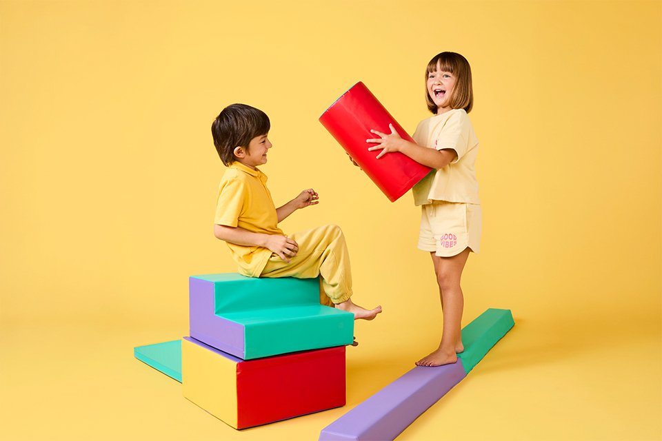 Two toddlers playing with Chad Valley's soft toys.